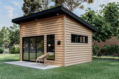 a small wooden shed with sliding glass doors and windows on the side, sitting in grass