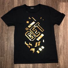 Available In “Like New” Condition Is A Zara Man Black/Gold “Get” T-Shirt Sz. Large. Comes From A Smoke Free Home-No Holes/Tears/Stains (See Pics-Indentation Noted). Bundle & Save - Add’l 15% Off When You Bundle 2+ Items. Note: I’m Pretty Meticulous About What I List, So Know I Will Disclose Any Flaws. However, I Apologize If There Are Ever Any Oversights. I Strive For 5-Star Service. Shirt Was Not Worn Only Tried On-Don’t Have Tags. Any ?’S Let’s Connect! Thanks For Shopping By & Follow Me! Gold T-shirt With Letter Print For Summer, Trendy Zara Graphic Print T-shirt, Trendy Zara T-shirt For Streetwear, Gold Crew Neck Top With Logo Print, Gold Cotton Tops With Logo Print, Tan Graphic Tee With Text Print, Casual Tan T-shirt With Graphic Print, Tan Graphic Tee With Letter Print, Gold Crew Neck T-shirt With Text Print