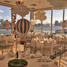 an indoor dining area with tables, chairs and balloons