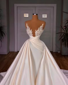 the back of a wedding dress on display in front of a mannequin's dummy