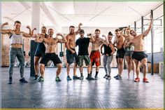 a group of young men and women posing for a photo in a gym with their arms up