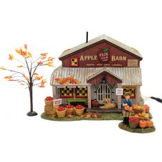 an apple barn with apples and other fruit on display next to a tree in front of it