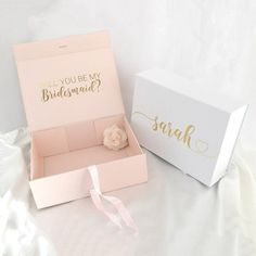 an open box with a flower inside and a pink ribbon tied around the bottom that says, will you be my bridesmaid?