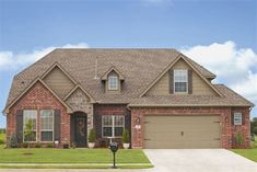 a large brick house with two garages in the front yard