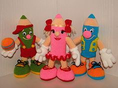 several crocheted toys are lined up on a shelf with one holding a ball and the other wearing shoes