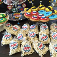 a table topped with lots of cookies and treats next to cupcakes on top of each other