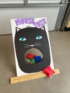 a cardboard cutout of a black cat with the word mouse toss on it