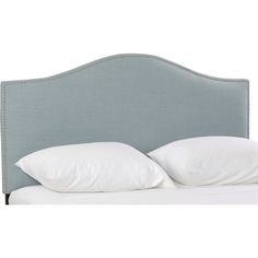 an upholstered headboard with two pillows on top of it and white sheets