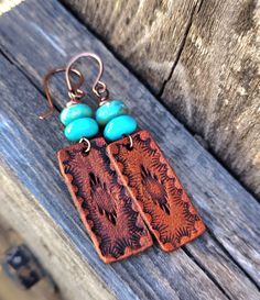 These earrings feature a hand stamped southwestern design and are dyed a medium brown and are topped with genuine Kingman mine turquoise beads...earrings hang from hand formed copper French style ear wires... Big enough to be seen yet super lightweight!  You'll reach for these earrings day after day.  *Please be aware of and allow for slight natural color variations in the turquoise.   Do you have sensitive ears?  I offer titanium ear wires and am happy to replace them on these earrings.  Simply Adjustable Stamped Dangle Earrings, Bohemian Turquoise Hand-tooled Earrings, Adjustable Artisan Hand Stamped Jewelry, Brown Stamped Jewelry For Festivals, Artisan Adjustable Hand Stamped Jewelry, Stamped Brown Jewelry For Festival, Bohemian Stamped Dangle Jewelry, Brown Stamped Copper Jewelry, Adjustable Rust-colored Nickel-free Jewelry