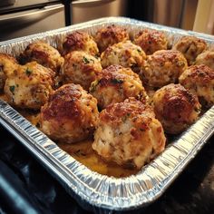 a pan filled with cooked meatballs on top of a stove