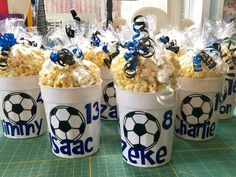 four buckets filled with popcorn sitting on top of a table