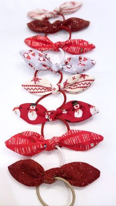 red and white hair ties with snowmen on them are lined up in a row