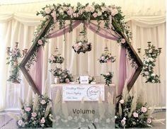 a wedding ceremony setup with flowers, candles and an arch over the table that has a sign on it