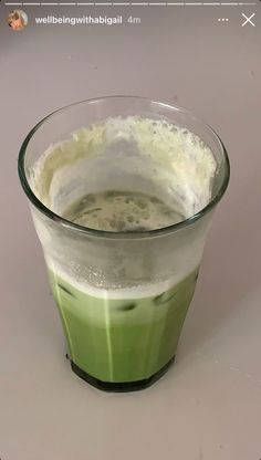 a green beverage in a glass on a table