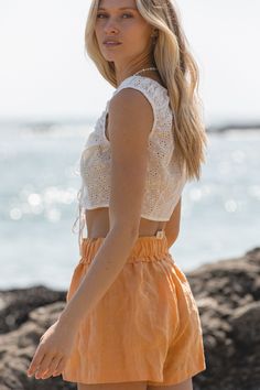 Introducing the Ojai Sun Cotton Eyelet Tank Top. This cropped tank features delicate eyelet detailing and a front tie. Perfect to tie over your swimsuit this summer. Pair with our Capri Linen Shorts to get this look! Spring Tie-side Swimwear For Day Out, Summer Beach Top With Drawstring, Summer Beach Tops With Drawstring, Summer Beachwear Tops With Drawstring, Summer Vacation Tops With Tie Waist, Drawstring Tops For Summer Beachwear, White Tie Back Crop Top For Vacation, Spring Swimwear With Drawstring Tie, White Tie-back Crop Top For Vacation