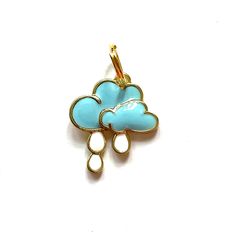 a blue and white cloud shaped charm on a white background