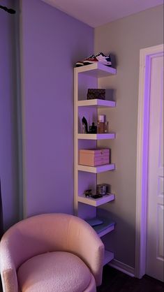 a purple chair sitting next to a white shelf