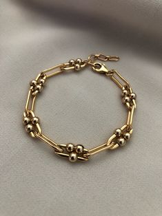 "A thick gold, long link bracelet with moving ball details. Made of high quality 14kt gold filled, this bracelet is a timeless staple for your wardrobe. Chain width is approximately 5.5mm. Gold filled balls are approximately 4mm. This listing is for the single gold chain bracelet. Measures: S/M 6\" with 1\" extender M/L 7\" with 1\" extender Length pictured at S/M ------------------------------------------------------------------------------------------------------------------- >> Check ou Luxury Gold Link Bracelet Fine Jewelry, Elegant Luxury Oval Chain Bracelet, Classic Gold Bracelets With Satellite Chain, Gold Bracelets With Satellite Chain In Classic Style, Elegant Metal Chain Bracelet With Satellite Chain, Gold Bracelets With Satellite Chain For Formal Occasions, Formal Gold Bracelets With Satellite Chain, 14kt Gold Jewelry, Dope Jewelry Accessories