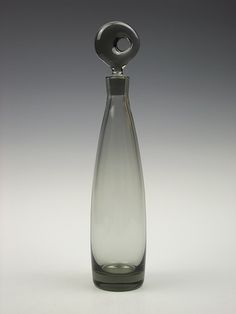 a clear glass vase with a metal handle