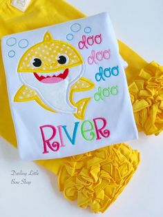 a white shirt with yellow ruffles and a baby shark on the front that says do not dog dag river