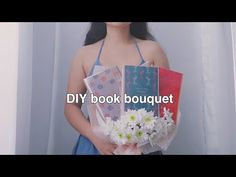 a woman is holding flowers and books in her hands with the words diy book bouquet