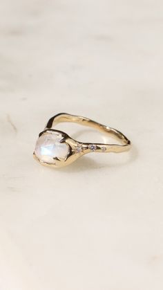 A rose cut moonstone is prong set in 14k yellow gold with star set diamonds along the band. This ring is made to order and can be made in any gold color and ring size. #moonstonering #moonstone #goldring #diamondengagementrings #engagementring #uniquerings Celestial Moonstone Ring With Rose Cut Diamonds, Celestial Moonstone Ring With Diamond, Celestial Moonstone Diamond Ring, Celestial Diamond Moonstone Ring, White Celestial Moonstone Ring In 14k Gold, White Moonstone Celestial Ring In 14k Gold, Alternative Engagement Rings, Engagement Ring Styles, Moonstone Ring