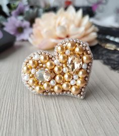 a heart shaped brooch sitting on top of a table