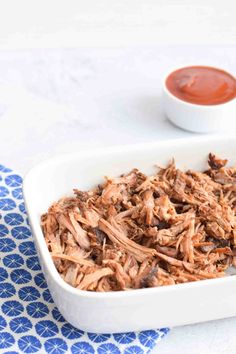 shredded pulled pork in a white dish with ketchup on the side and text overlay reading low fodmap pulled pork