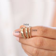 a woman's hand with three different rings on her finger and the measurements for each ring