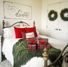 a bedroom decorated for christmas with wreaths on the headboard and bed in front