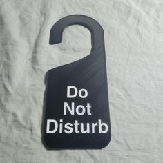 a black door hanger with the words do not disturb written in white on it