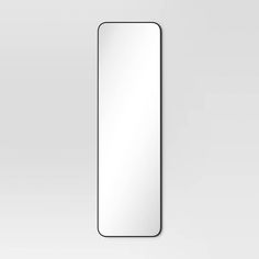 a white rectangular mirror hanging on the wall