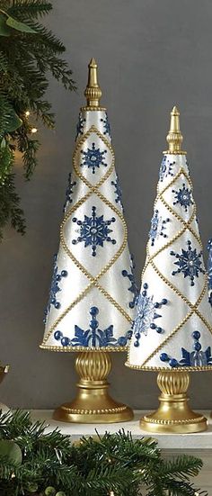 three blue and white christmas trees sitting on top of a mantle