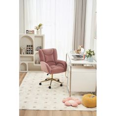 a pink chair sitting on top of a white rug next to a desk and bookshelf