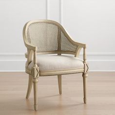 a white chair sitting on top of a hard wood floor next to a wall and door