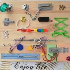 many different types of toys and accessories on a wooden surface with chains, hooks, keys, and magnets