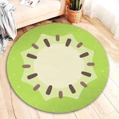 a green rug with brown spots on it in the middle of a wooden floor next to a couch