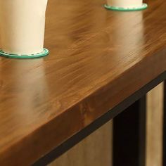 three white cups sitting on top of a wooden table