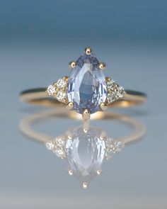 Delicate and Graceful Pastel Blue Pear Sapphire Engagement Ring in 14K Rose Gold We are glad to introduce our beautiful Sapphire Engagement Ring. Pear shaped stone with diamonds on the sides dresses the hand in an infinite variety of ways. The lightness and airiness of this pastel blue sapphire ring evoke the poetic nature. All of these details come together in total refinement enhancing the center light blue gem. This wonderful engagement ring truly is a symbol of timeless elegance.  Sapphire and Diamond Engagement Ring Details: Main Stone: 2 - 2.10 ct  Natural Pastel Blue Sapphire Pear Shape  Side Stones: 6 Natural Round Brilliant Diamonds  Metal: 14K Gold This Unique Sapphire Engagement Ring can be customised in Rose,White and Yellow Gold. The Sapphire has gorgeous pastel  light blue co Promise Sapphire Ring With Rose Cut Diamonds, Promise Rings With Rose Cut Diamonds And Sapphire, Brilliant Cut Pink Sapphire Ring In Fine Jewelry Style, Fine Jewelry Pink Sapphire Ring With Brilliant Cut, Brilliant Cut Pink Sapphire Ring Fine Jewelry, Pink Sapphire Ring With Brilliant Cut, Brilliant Cut Pink Sapphire Ring, Sapphire Promise Ring With Rose Cut Diamonds, Sapphire Diamond Ring With Rose Cut For Promise