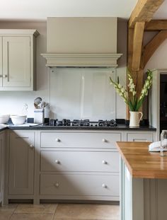 a kitchen with white cabinets and wooden counter tops