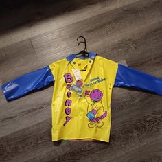 a child's yellow and blue raincoat with the words happy birthday on it