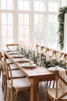 a long table with candles and greenery on it