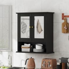 a black cabinet with two glass doors in a white kitchen area next to a sink