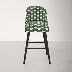 an upholstered chair with a green and white patterned seat cover on the back