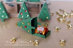 small christmas trees made out of green paper and gold foil confetti on a wooden table