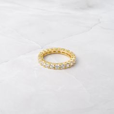 Beautiful eternity band, that sparkles and glistens like no other! Looks great on its own or paired with other rings! - - - D E T A I L S - - -  * Made of 925 Sterling Silver * We use a Durable, THICK plating of 14k Gold or Rhodium - for a piece that will last you years to come!  * Stone measures 3mm  * Eternity-style band  * Nickel-free & Hypoallergenic * Available in sizes 4-12 Ring Sizer- https://www.etsy.com/listing/1240904225/ring-sizer-reusable-ring-sizer-plastic?click_key=b5e074cfb419bcfd Adjustable Eternity Band With Prong Setting, Cubic Zirconia Eternity Band With Halo For Promise, Promise Ring Cubic Zirconia Eternity Band With Halo, Adjustable Half Eternity Band Ring, Cubic Zirconia Halo Eternity Band Promise Ring, Stackable Cubic Zirconia Crystal Ring With Round Band, Cubic Zirconia Eternity Band With Halo, Minimalist Cubic Zirconia Eternity Band With Prong Setting, Cubic Zirconia Halo Eternity Band