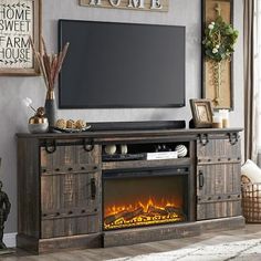 an entertainment center with a fireplace in the middle and pictures on the wall above it