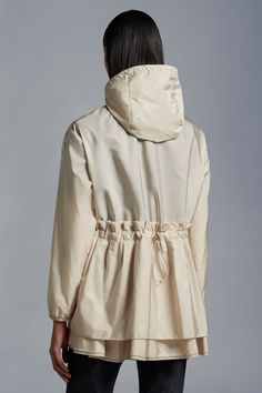 A crisp, breathable piece for the summer months, the Wete jacket fuses femininity with practicality. Crafted from nylon technique, the hooded jacket has a silky smooth, water-repellent texture. A fitted waistline and gathered silhouette confer femininity to the piece. Beige Parka With Drawstring Hood, Hooded Raincoat With Double-lined Hood, Beige Nylon Outerwear With Drawstring Hood, Spring Windbreaker With Adjustable Hood, Cream Hooded Nylon Outerwear, Cream Nylon Hooded Outerwear, Hooded Beige Nylon Windbreaker, Beige Hooded Nylon Windbreaker, Long Rain Coat