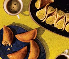 some food is sitting on a plate next to two cups and saucers with spoons