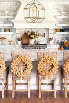 four chairs with wreaths on them sitting in front of a counter